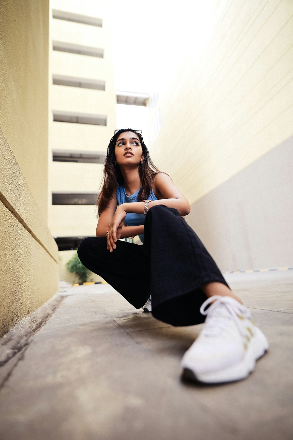 a woman sitting on the ground in front of a building