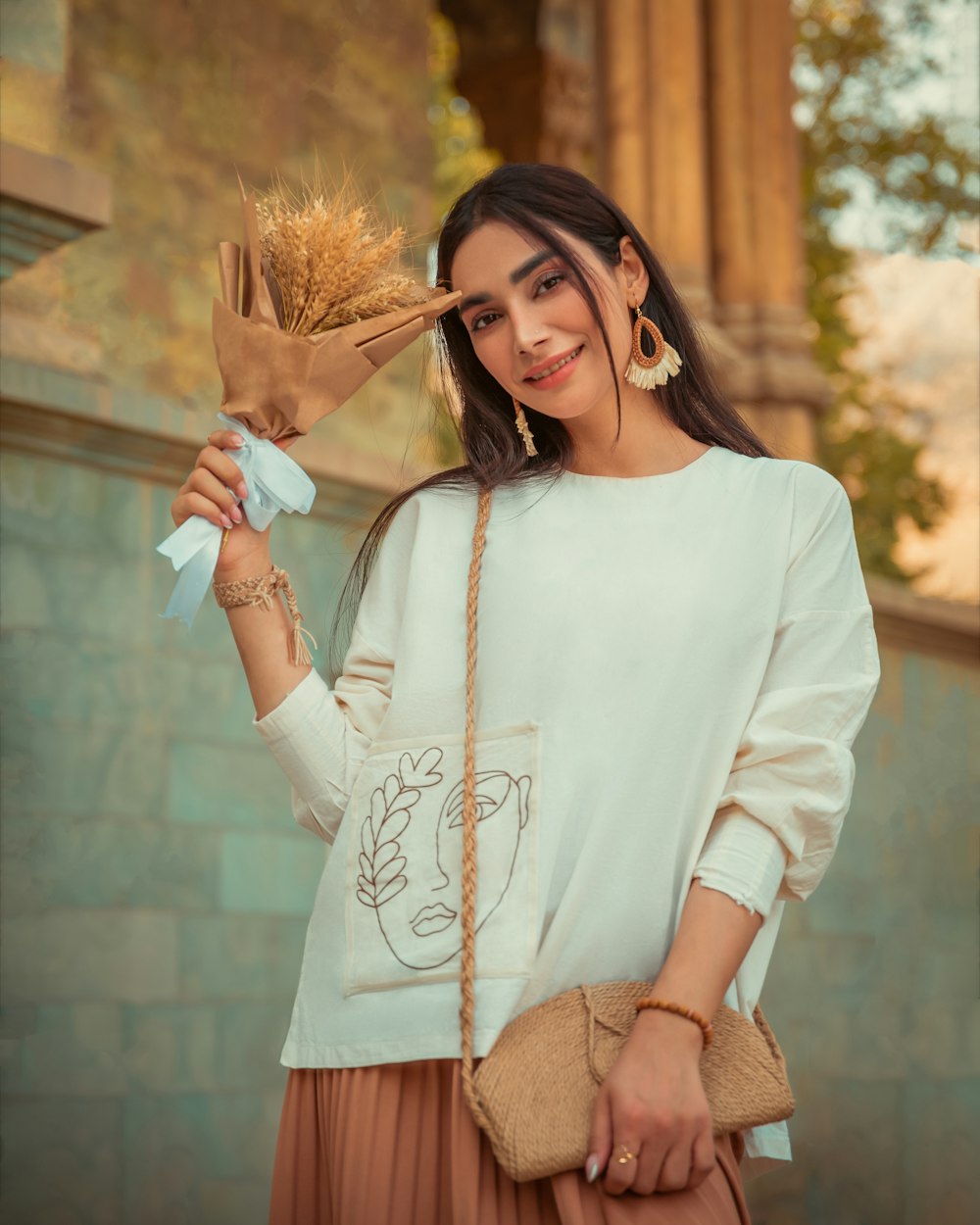 a woman holding a bunch of wheat in her hand