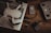 A drone with propellers is placed on a laptop keyboard alongside a battery, a remote controller, multiple SD cards, and a memory card reader on a wooden surface. The arrangement of these items suggests preparation for a video or photography session.