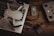 A drone with propellers is placed on a laptop keyboard alongside a battery, a remote controller, multiple SD cards, and a memory card reader on a wooden surface. The arrangement of these items suggests preparation for a video or photography session.