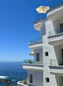 Modern beachfront apartment building with balconies overlooking the sea.