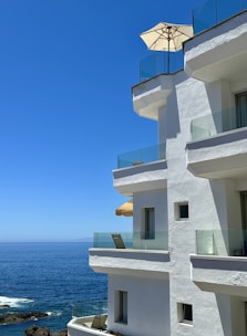 a white building with a balcony overlooking the ocean