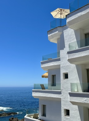 Modern beachfront apartment building with balconies overlooking the sea.
