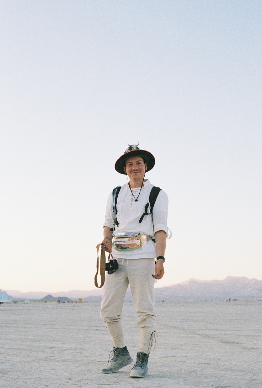 a man wearing a hat and holding a camera