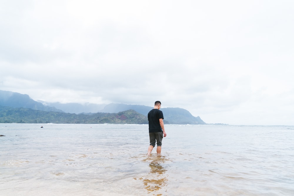 Un hombre parado en el agua en la playa