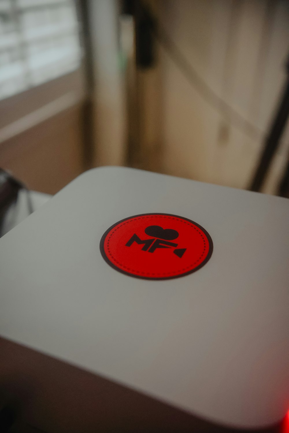 a close up of a white table with a red button