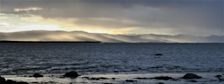 A serene landscape with light breaking through clouds.