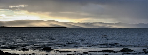 A serene landscape with light breaking through clouds.