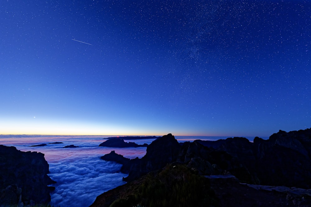 a view of the night sky from the top of a mountain
