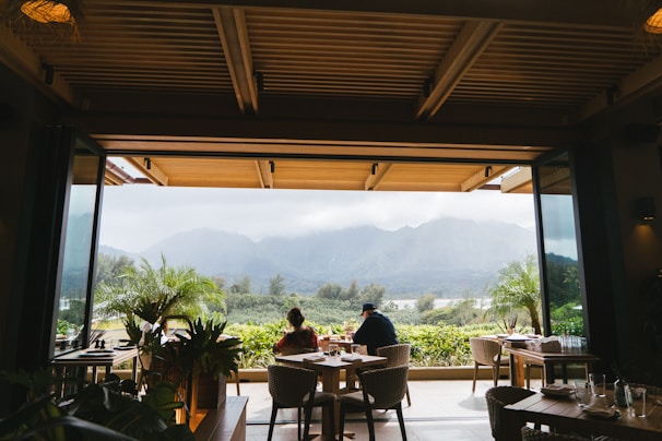 Smiling travelers sharing a meal of authentic Balinese cuisine in a cozy outdoor setting.