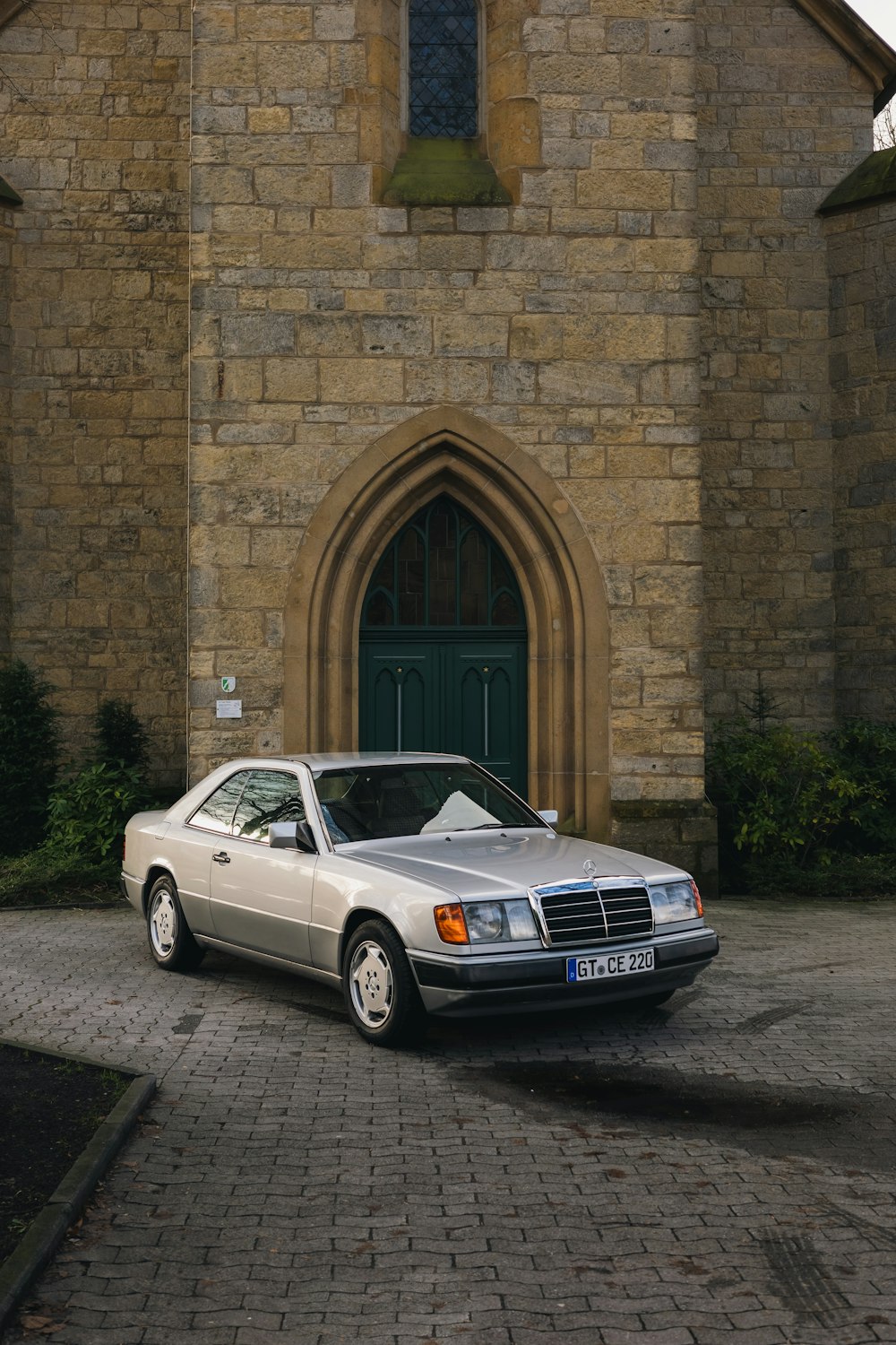 a silver car parked in front of a church