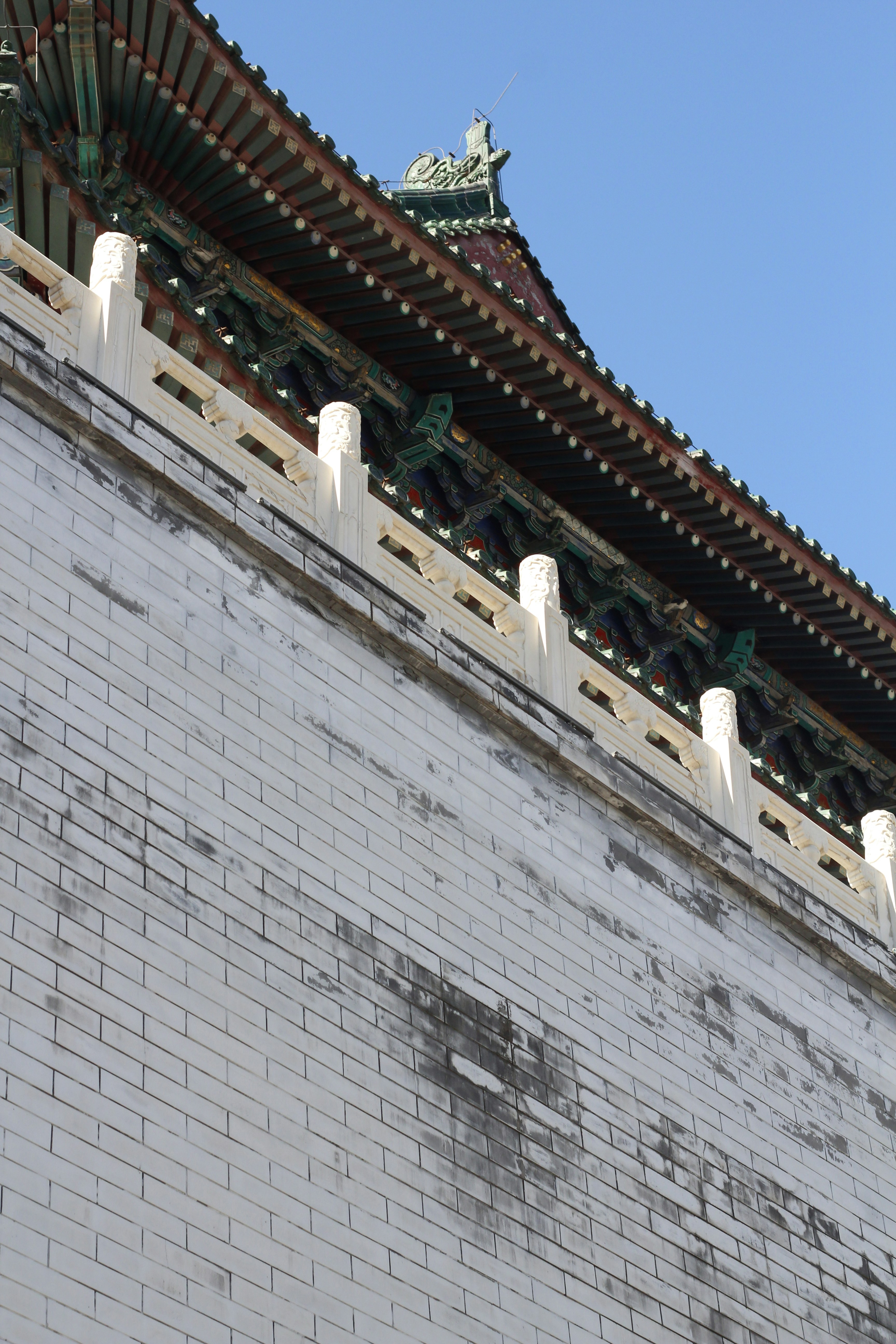 レンガの壁の上に時計が乗っている