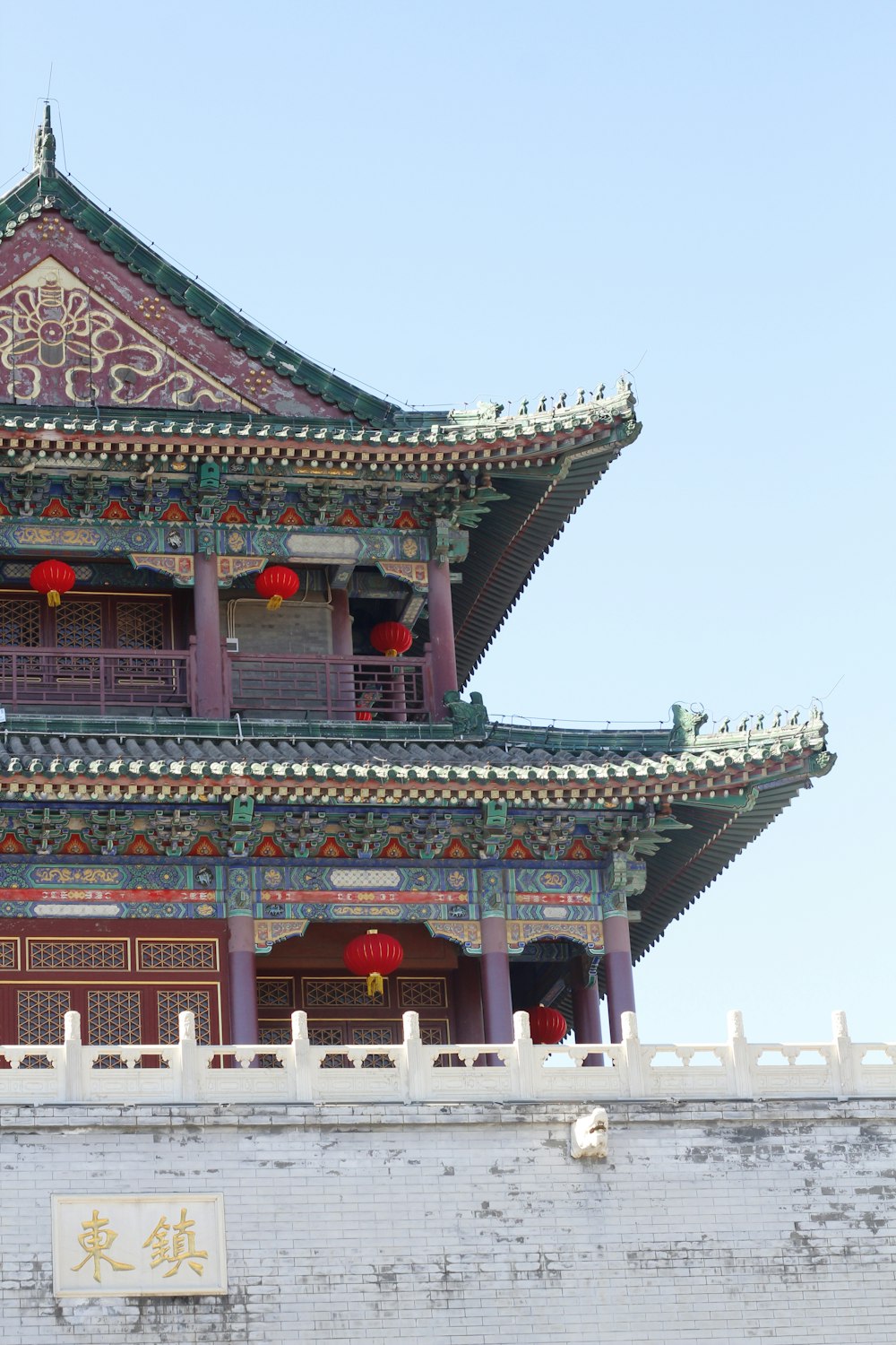 a tall building with red lanterns hanging from it's roof