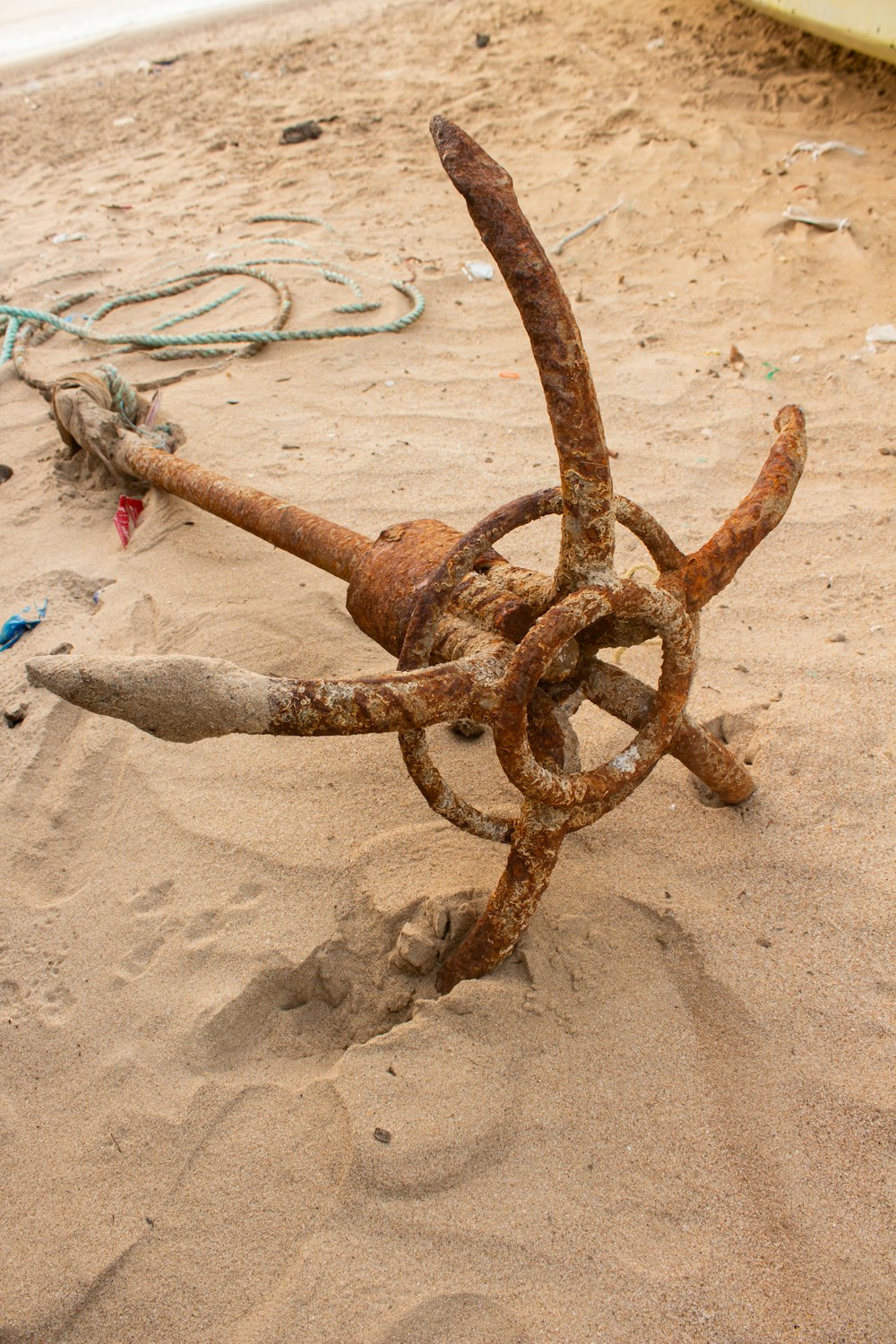 a rusty anchor on a sandy beach