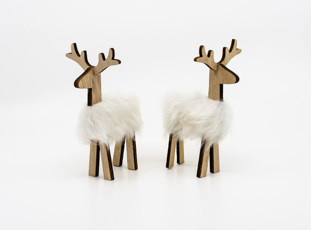 a pair of deer made out of wood and fake fur