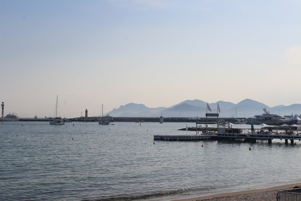 um corpo de água com barcos e montanhas ao fundo