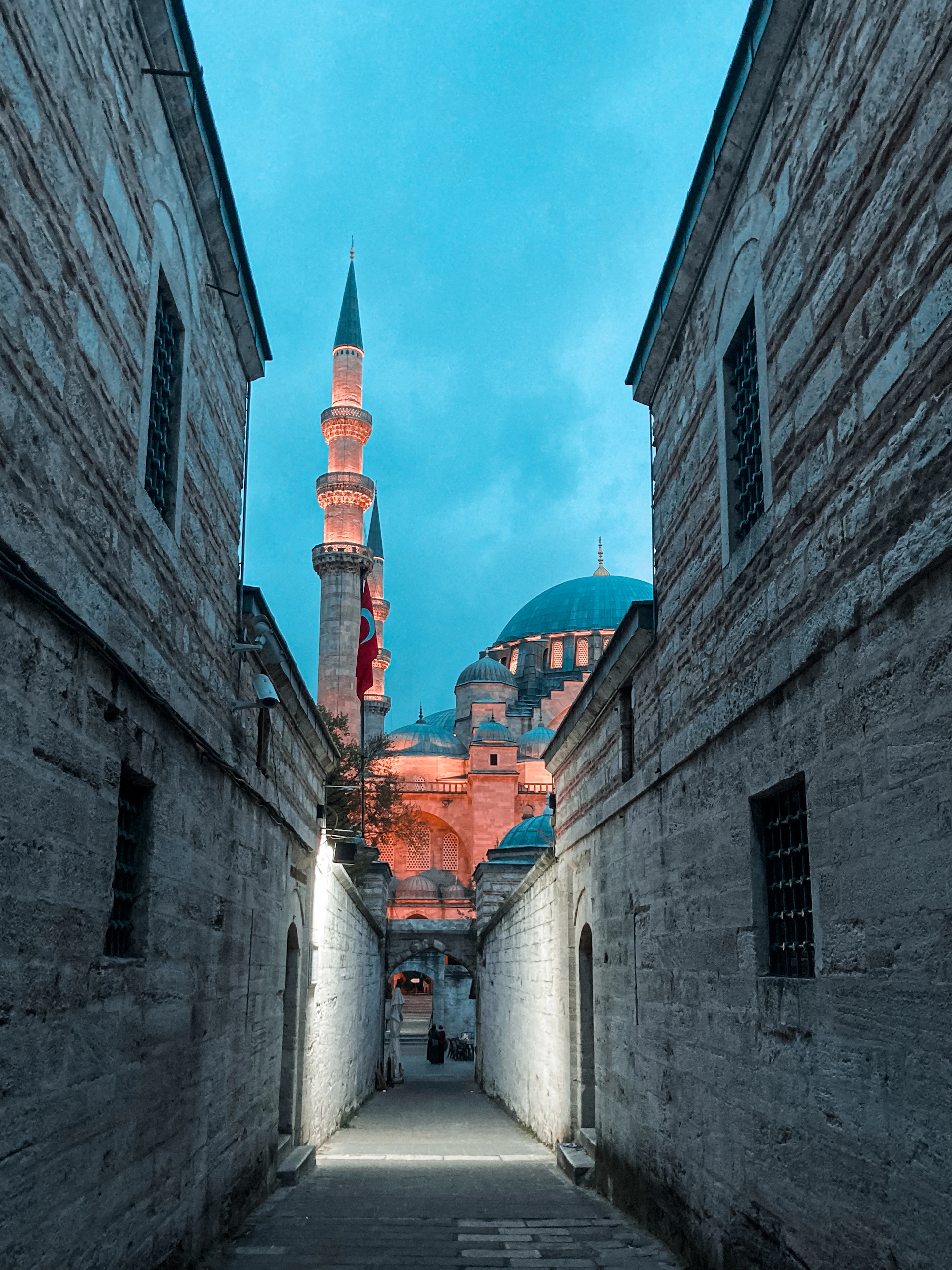 a narrow alley way with a building in the background