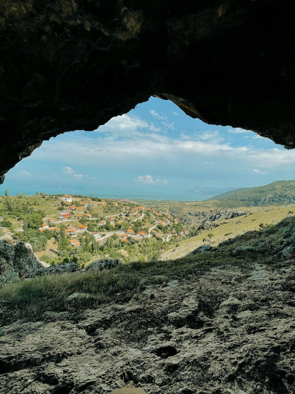 a view from inside of a cave looking at a town