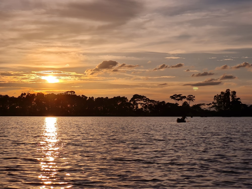 the sun is setting over a body of water