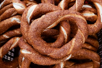 Close-up of freshly baked golden pretzels stacked on a rustic wooden tray.