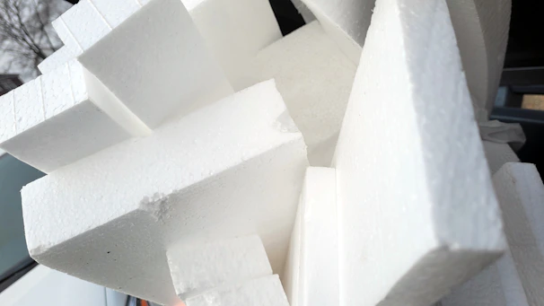 Close-up of a polystyrene caseton being carefully inspected in a modern factory setting.