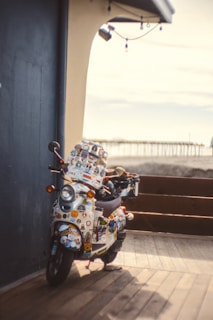 Close-up of colorful scootin my way stickers on a scooter deck in bright sunlight.