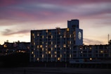 Evening shot of a completed building glowing softly against the sky.