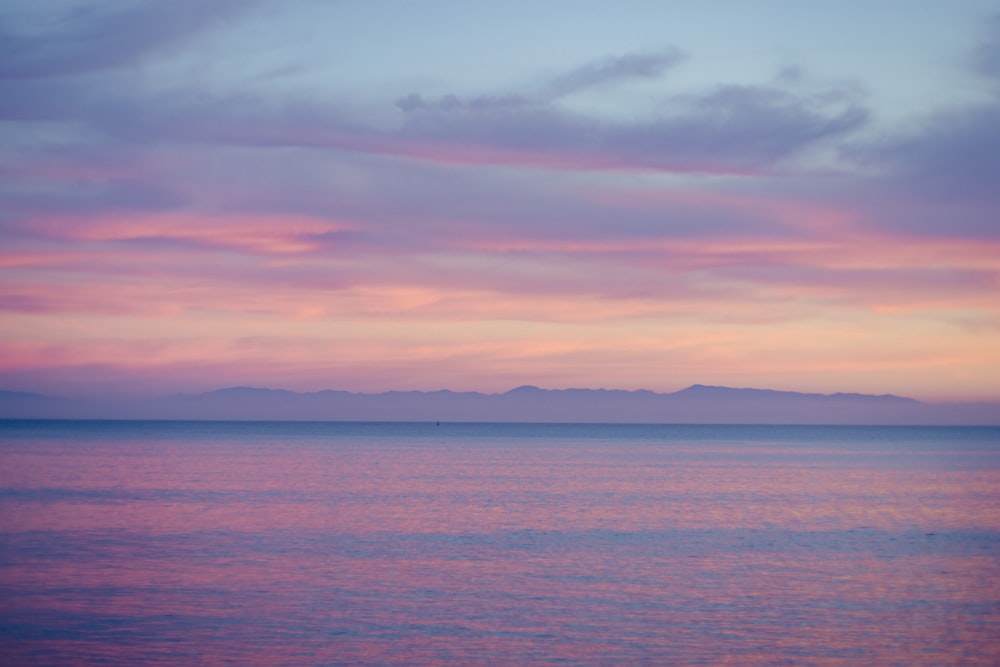 a large body of water sitting under a cloudy sky