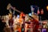 A decorative scene with large toy soldier figures dressed in traditional, colorful uniforms. The main figure is holding a trumpet, set against a vibrant background of lights and festive decorations.