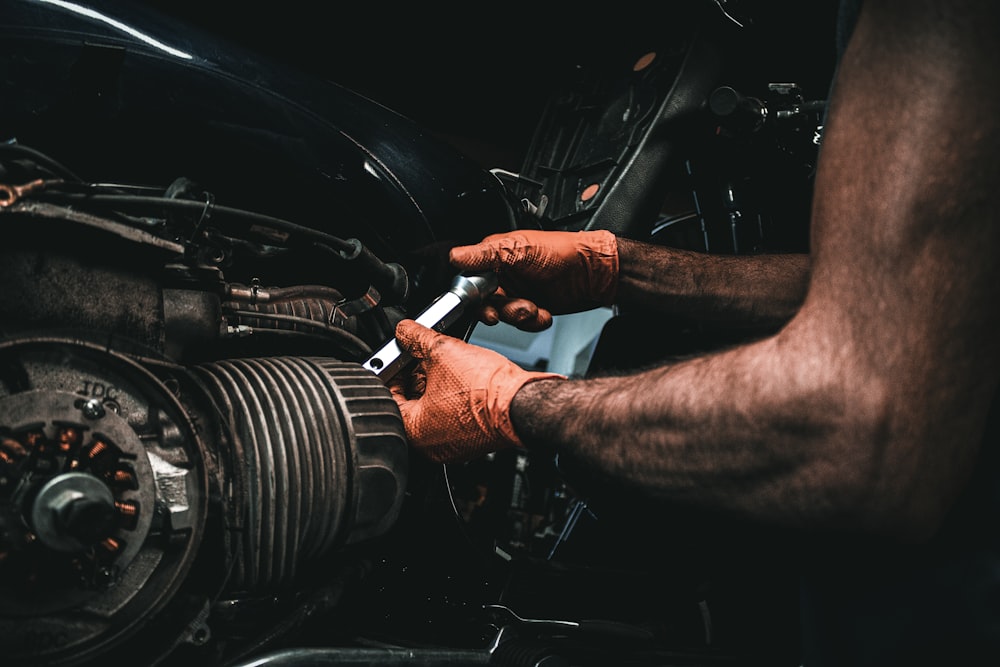 a man working on a car engine with a wrench
