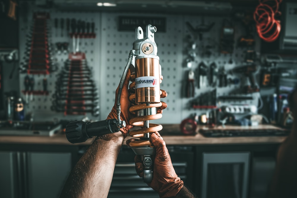 a man holding a drill in a garage