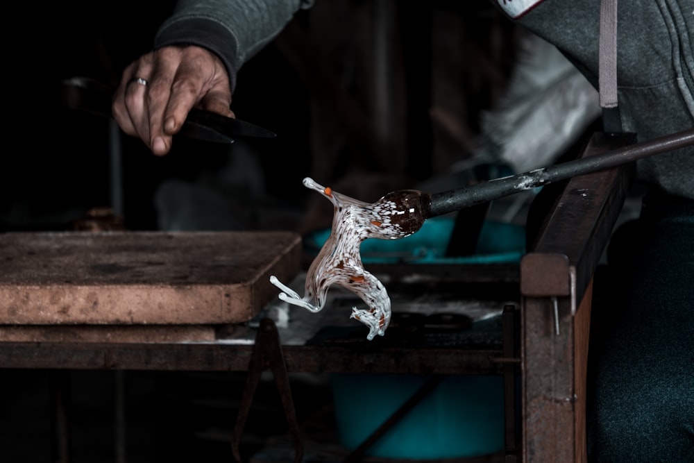 a person holding a knife and a broken glass figurine