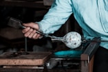 a man holding a pair of tongs with a ball on it