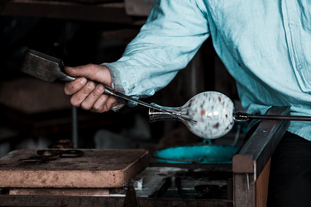 a man holding a pair of tongs with a ball on it