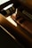 Several skincare products are placed inside a cardboard box, with sunlight creating a warm glow. The products have elegant, minimalist packaging, with one prominently visible pink tube labeled 'Aesop.' The lighting enhances the luxury aesthetic.