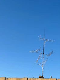 Antenna installation on top of a hotel roof under a clear sky.