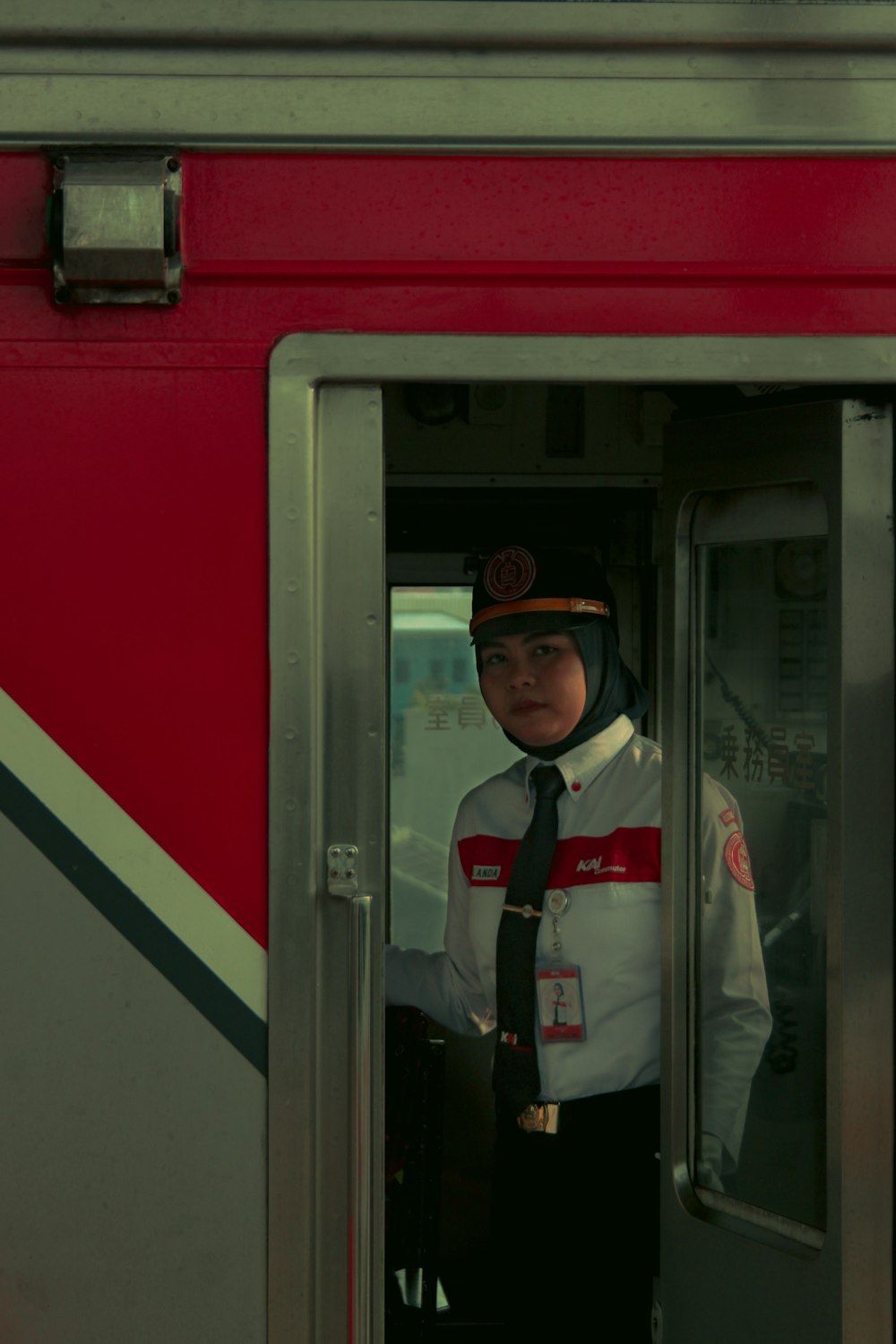 a man in uniform standing in the doorway of a train