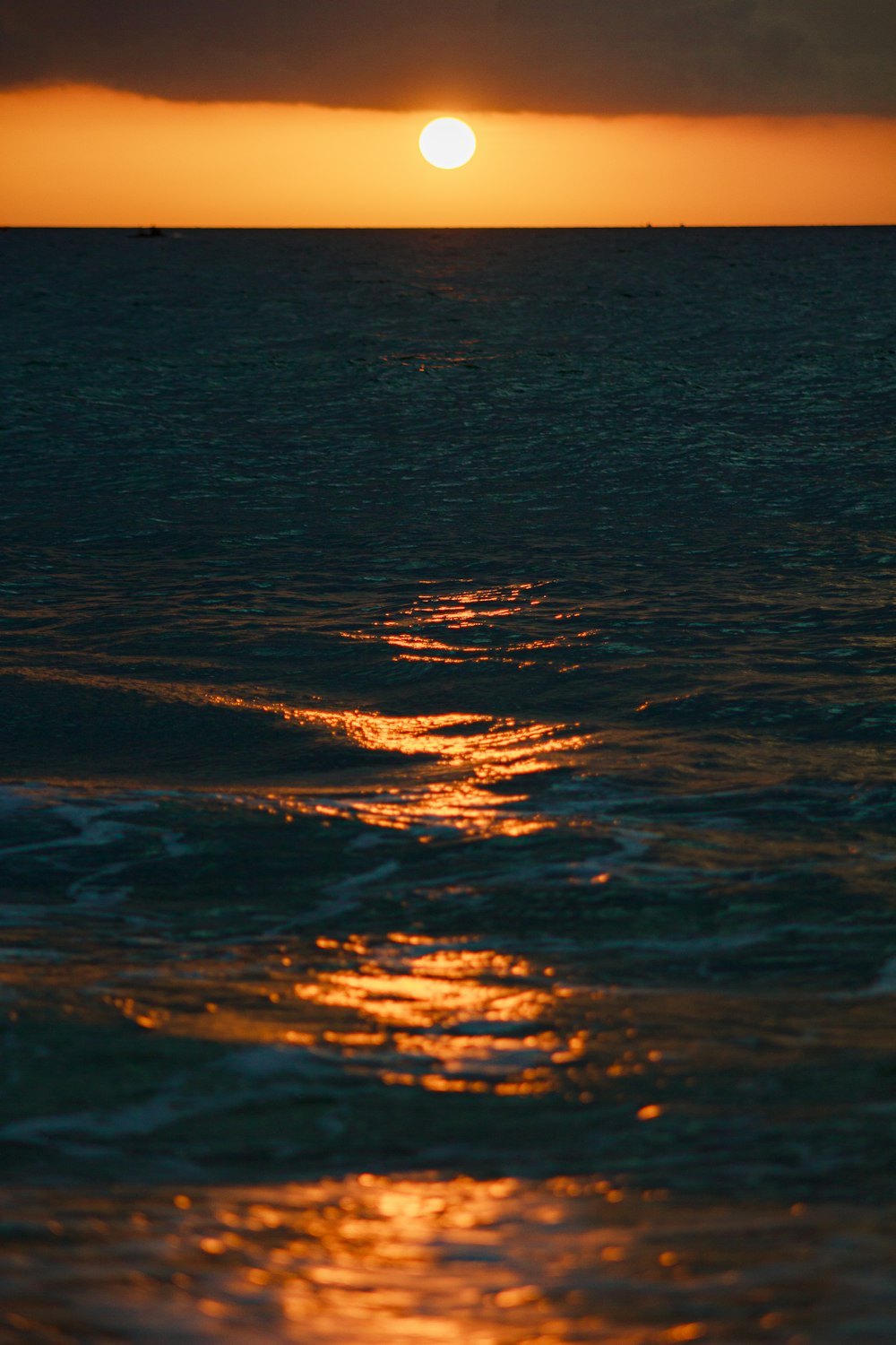 the sun is setting over the ocean with waves