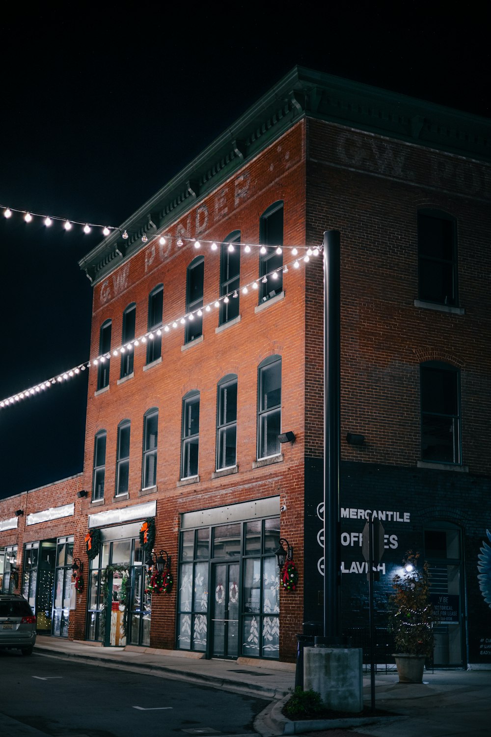 a red brick building with a string of lights on it