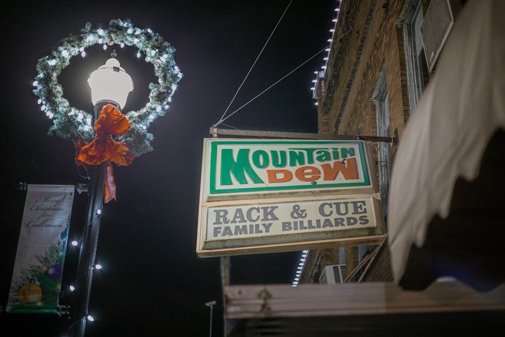 a mountain dew sign with a wreath hanging from it's side