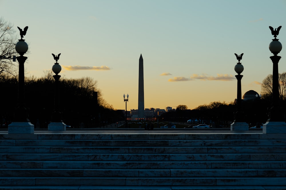 the washington monument is silhouetted against the sunset