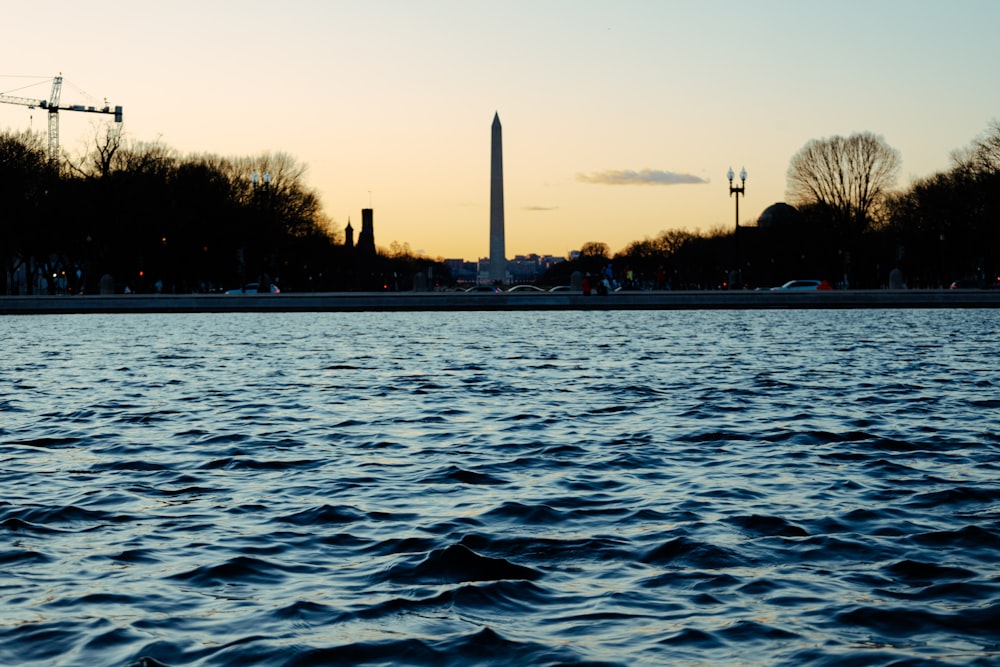 a body of water with a tower in the background