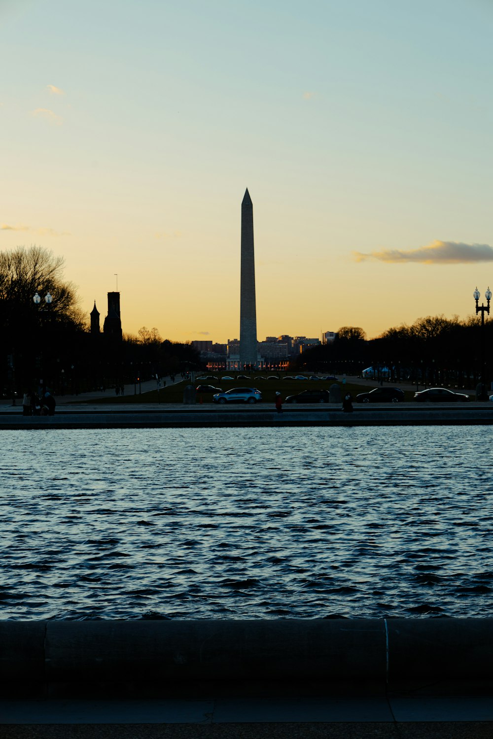 the washington monument is silhouetted against the sunset