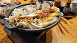 A steaming bowl of seafood hotpot with fresh herbs and spices