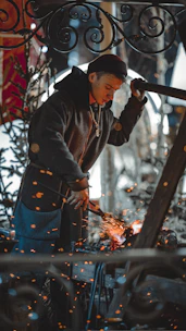 Artisan crafting a custom metal lamp, sparks flying gently as the piece takes shape in a cozy workshop.
