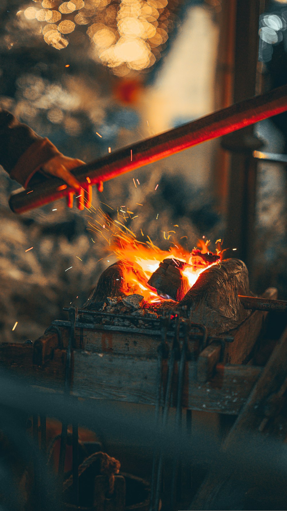 a person holding a stick over a fire