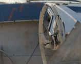 Close-up of weathered hands gripping the boat’s steering wheel during a storm.