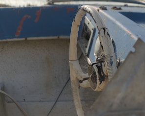 Close-up of weathered hands gripping the boat’s steering wheel during a storm.
