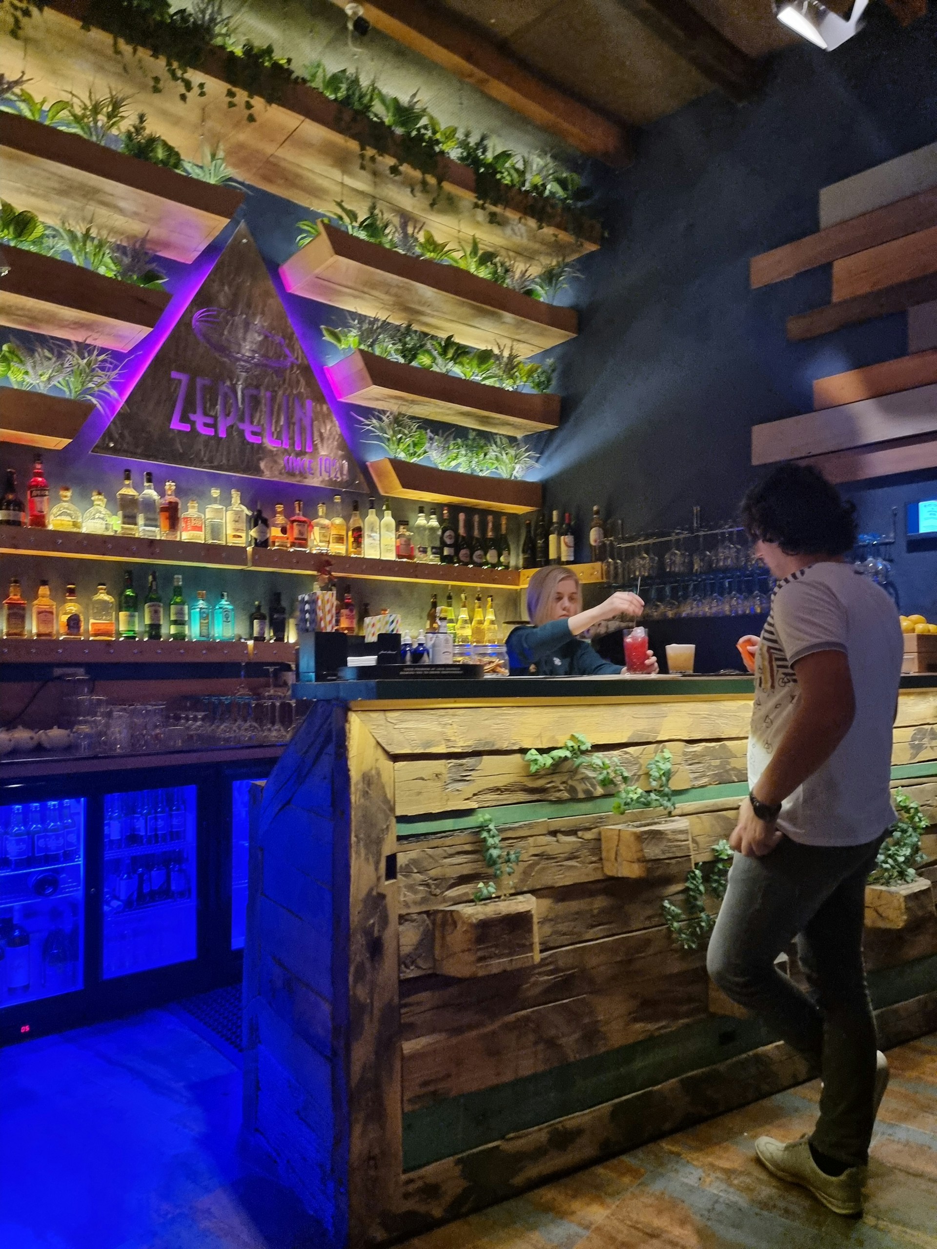 Close-up of a rustic wooden bar decorated with vintage Western memorabilia and themed cocktails being served.