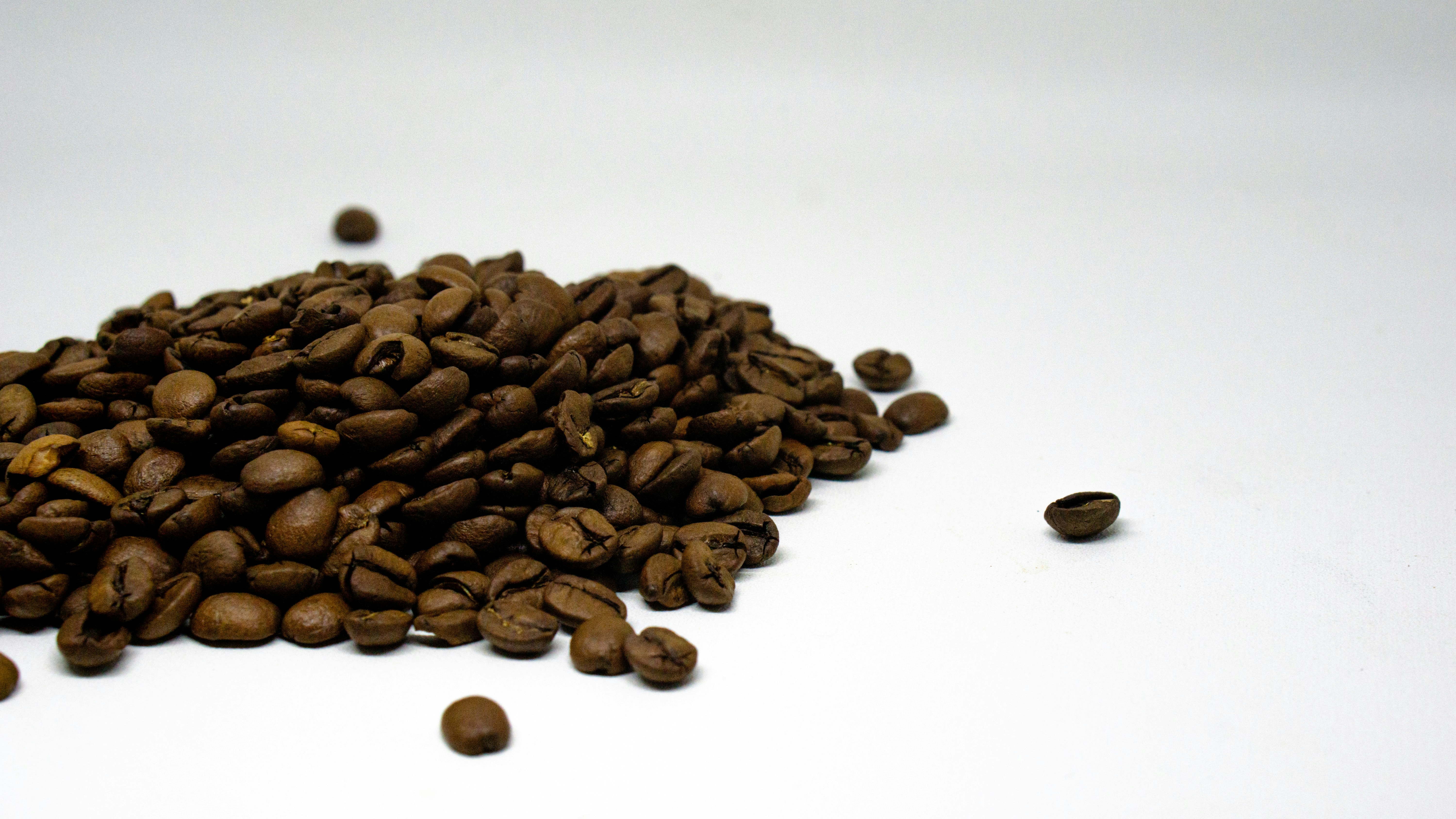 a pile of coffee beans sitting on top of a white table